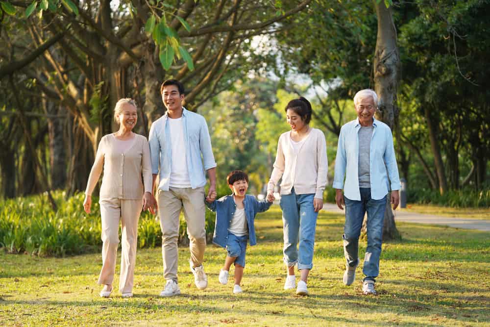 Familie mit Kind und Großeltern unterwegs im grünen Wald Spaziergang. Muttertag Spaziergang.